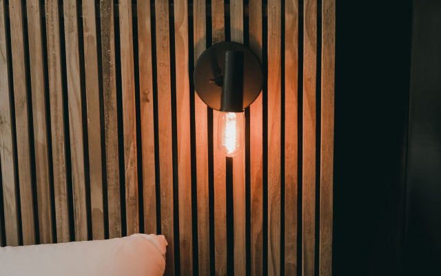 Habillage mural en bois formant tête de lit dans une chambre