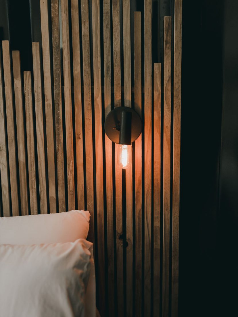Habillage mural en bois formant tête de lit dans une chambre