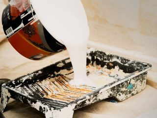 Peinture blanche versée dans un pot